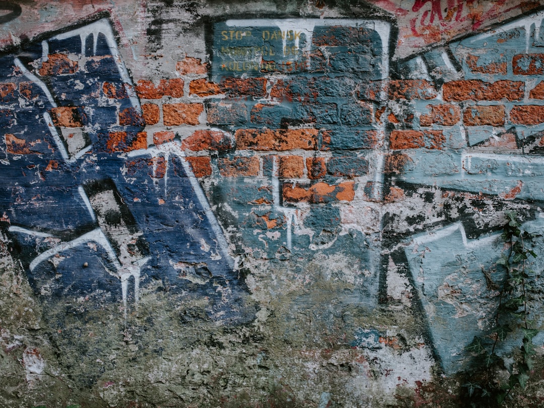 Street graffiti techniques on a weathered urban wall with spray cans, layered paint, and stencil textures